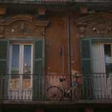 Foto 17. Unici invece sono i timpani che abbelliscono un balcone del palazzo adiacente, di cui uno caratterizzato dalla testa di un leone, che potrebbero far sembrare elegante questa casa, se non fosse per i modesti panni stesi e una bicicletta arrugginita che rivelano il carattere popolare dell�abitazione 